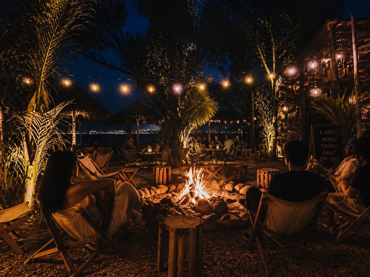 Guests seated in canvas chairs around a lit fire pit under string lights at ASAP & SOUL