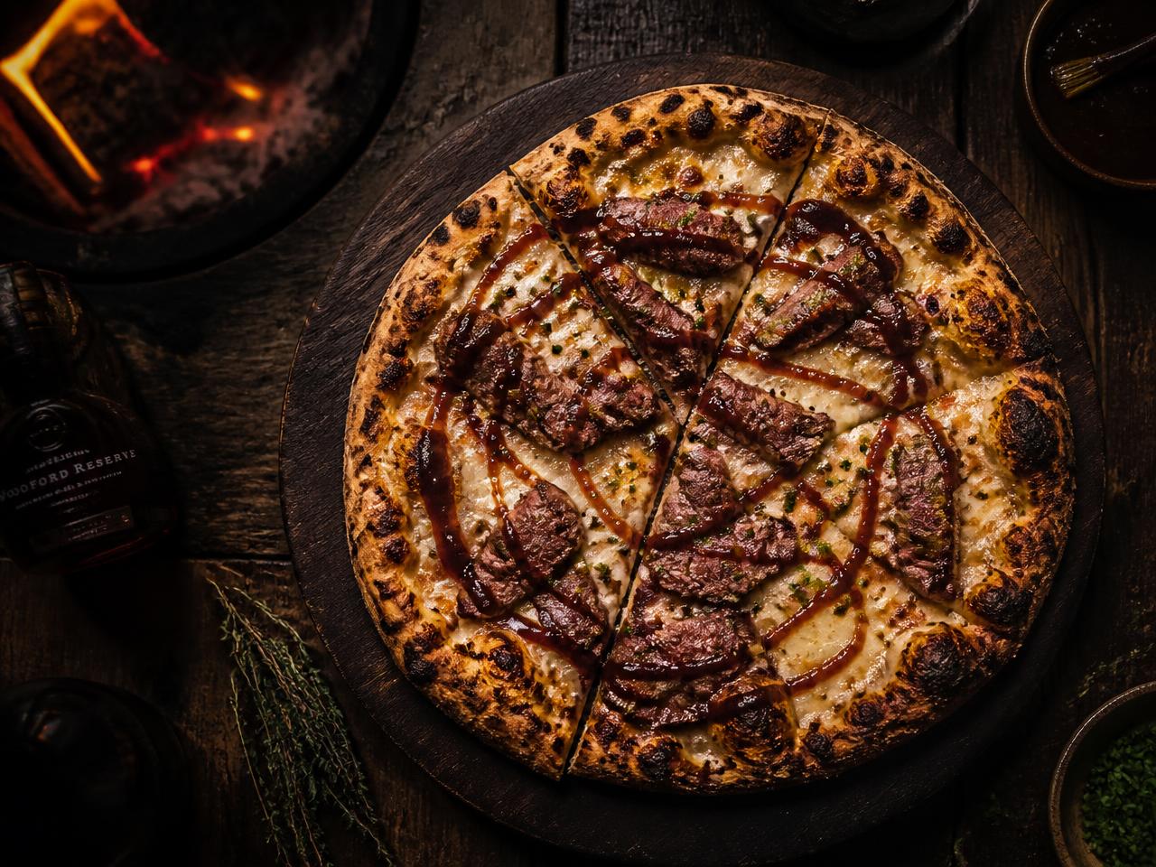Smokey wagyu pizza with BBQ sauce and mozzarella on a dark wooden board